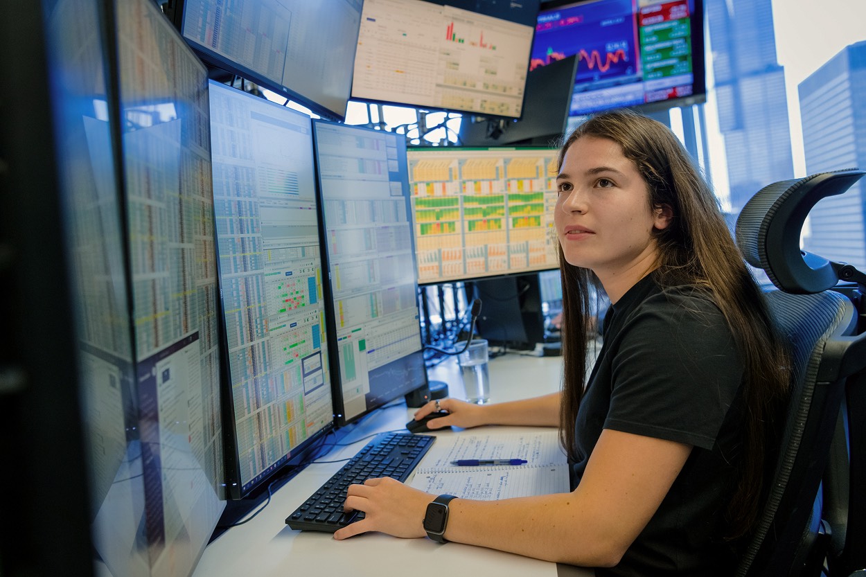 team member working at trading desk monitor set up